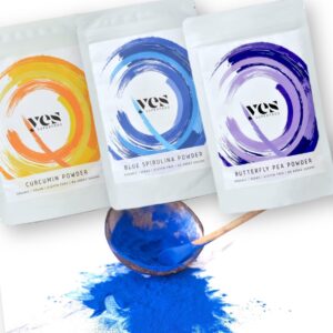Yes Superfood Curcumin, Blue Spirulina és Butterfly Pea porok kreatív kompozícióban, fa kanalakon színes porokkal.