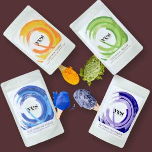 Yes Superfood Curcumin, Matcha, Blue Spirulina és Butterfly Pea porok kreatív, színes kompozícióban fa kanalakkal.